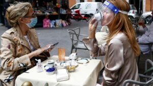 Dos personas sentadas en una terraza en Roma italia coronavirus